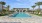 a swimming pool with palm trees and a building in the background